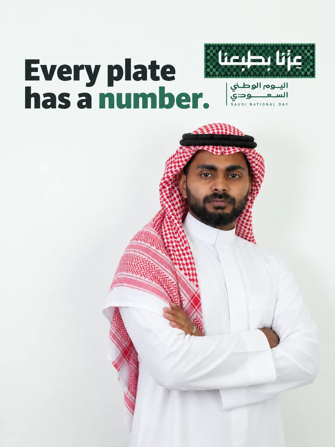 Aadil Aman, co-founder of Nombur, in a thobe and shemagh, with the line Every plate has a number and the Saudi National Day 96 slogan عزّنا بطبعنا